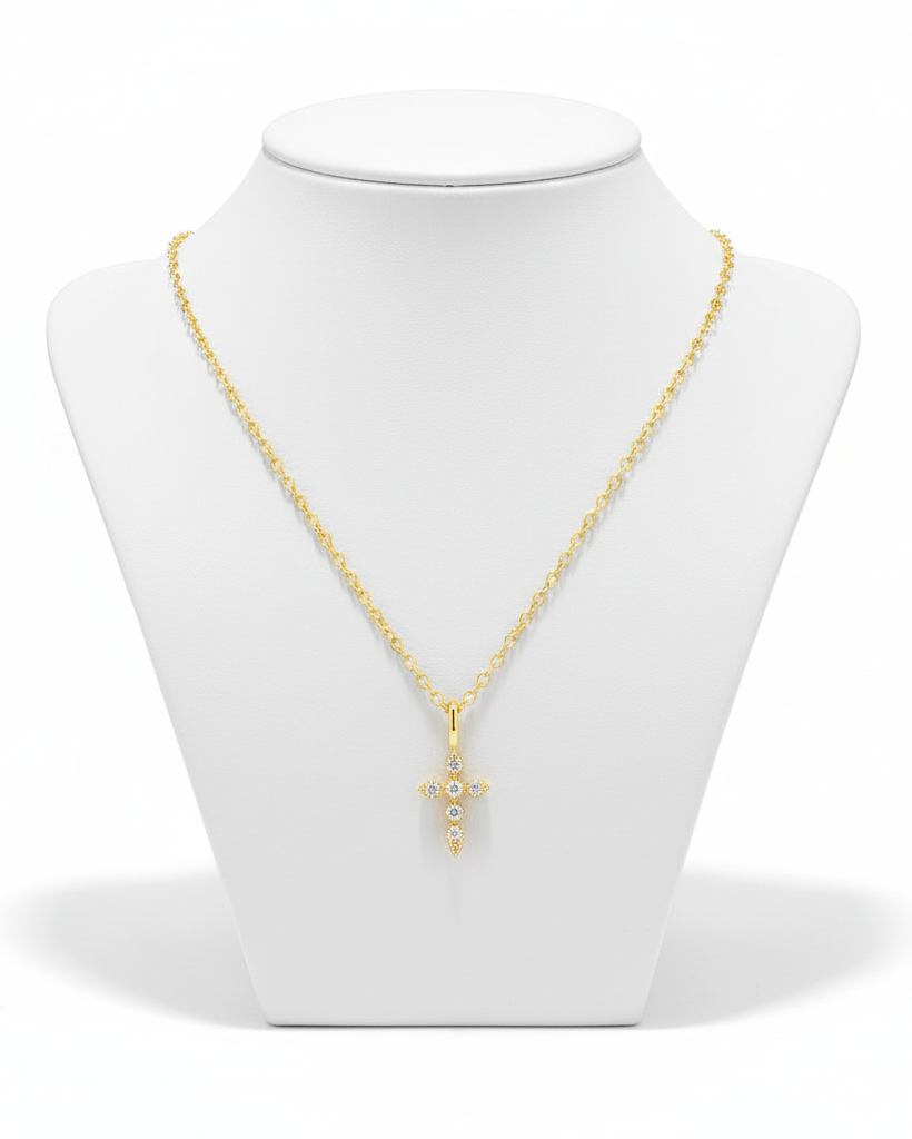 Filigrane goldene Kreuz-Halskette auf weißem Hintergrund